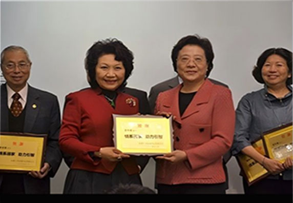 時任中央政府駐港聯絡辦副主任仇鴻（右）向王中英董事長頒發個人貢獻獎